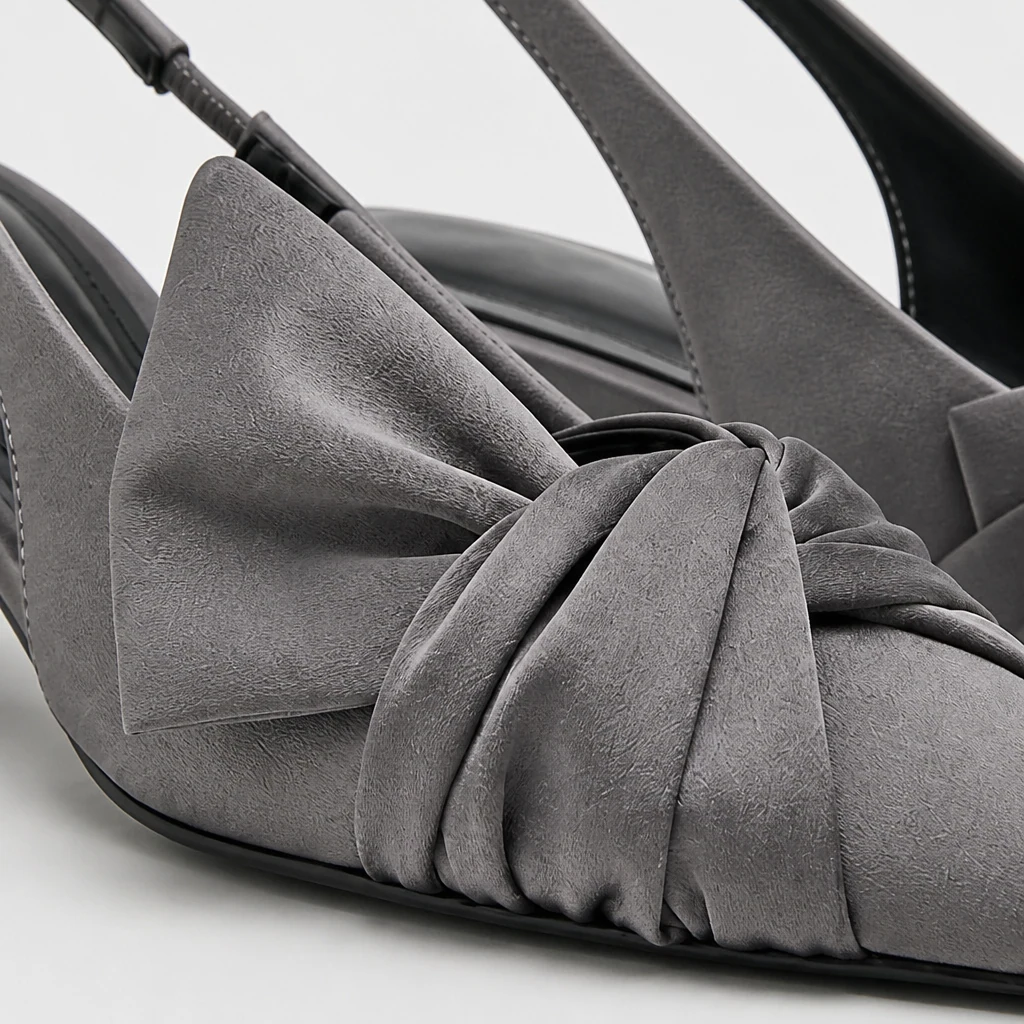 Close-up van grijs slingback-pumpmateriaal, strikdetail, puntige neus en hielconstructie